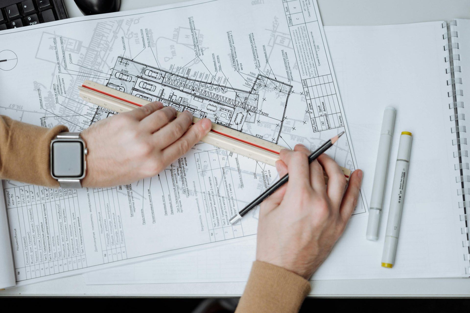 Ein Architekt verwendet Lineal und Bleistift für Baupläne und stellt so Arbeitsbereich und Planung dar.