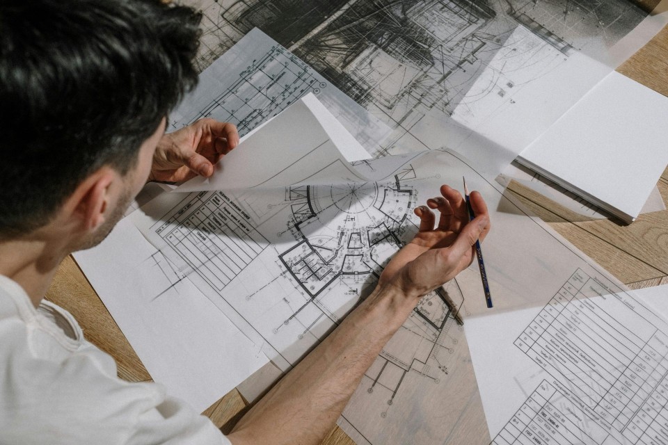 Architekt studiert und skizziert detaillierte Architekturpläne im Innenbereich.